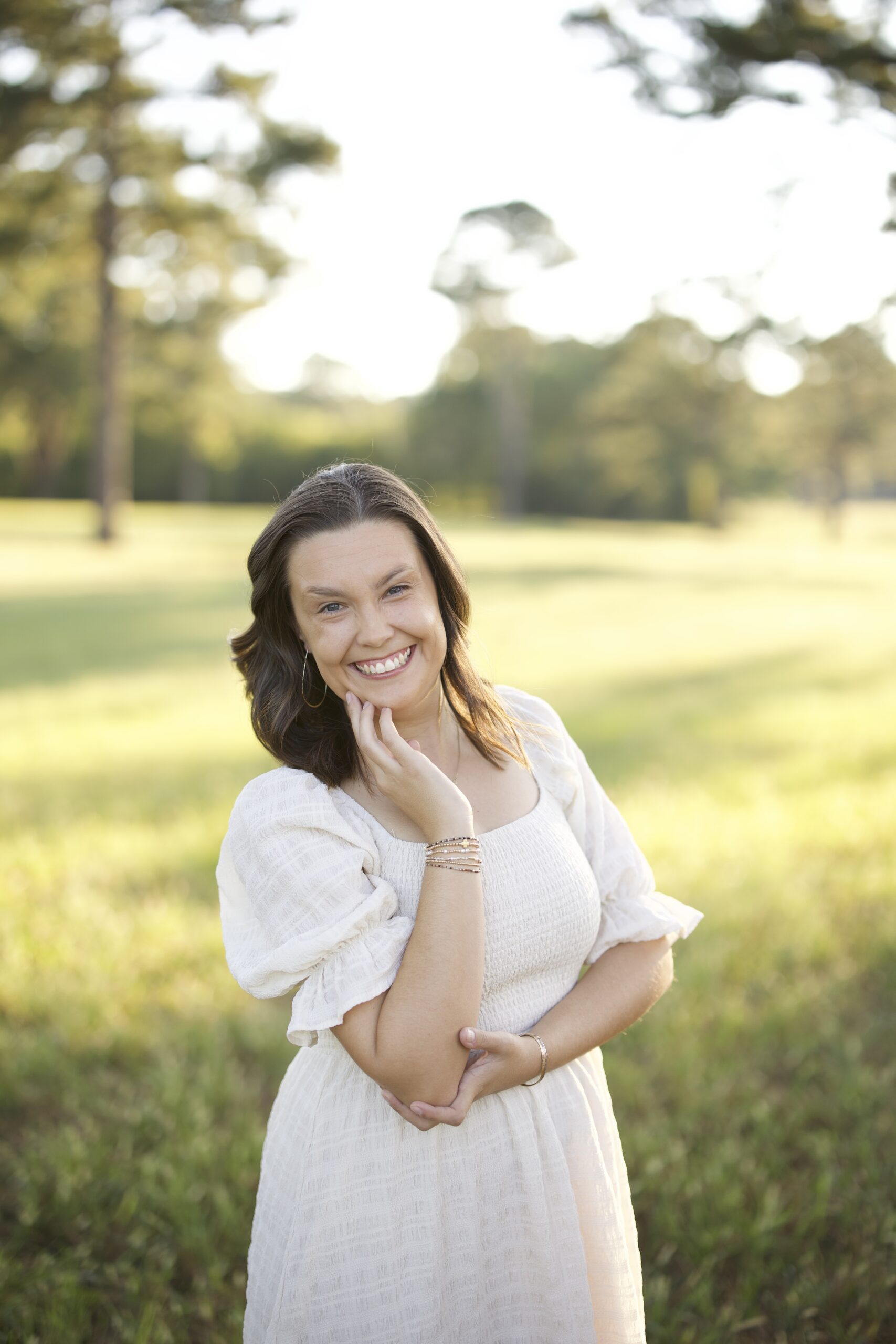 Birmingham AL family photographer Elle Lovelace smiling in a golden field at sunset